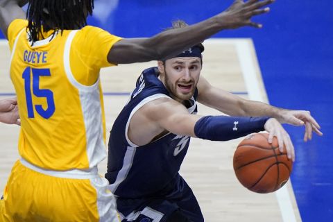 Monmouth guard George Papas, right, looks to get off a pass with Pittsburgh forward Mouhamadou Gueye (15) defending during the first half of an NCAA college basketball game in Pittsburgh, Sunday, Dec. 12, 2021. (AP Photo/Gene J. Puskar)