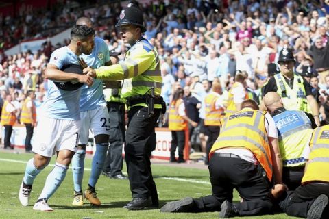 Manchester City's Sergio Aguero is held back by police after going up the a stewards, right, who were dealing with a fan on the pitch after Raheem Sterling, not in picture, celebrates scoring his side's second goal during the Premier League soccer match between AFC Bournemouth and Manchester City at the Vitality Stadium, Bournemouth, England. Saturday Aug 26, 2017. (Steve Paston /PA via AP)/PA via AP)