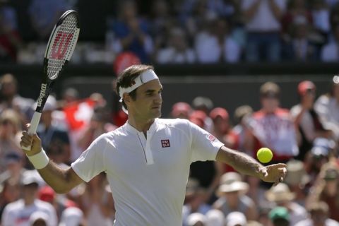 Roger Federer of Switzerland sends a ball into the tribunes after defeating Serbia's Dusan Lajovic, in their Men's Singles first round match at the Wimbledon Tennis Championships in London, Monday July 2, 2018. (AP Photo/Tim Ireland)