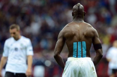 Italian forward Mario Balotelli takes his top off after scoring during the Euro 2012 football championships semi-final match Germany vs Italy on June 28, 2012 at the National Stadium in Warsaw.           AFP PHOTO / CHRISTOF STACHE        (Photo credit should read CHRISTOF STACHE/AFP/GettyImages)