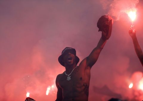 A Corinthians fan celebrate his team's victory over Fluminense, amid red flares at a Brasileirao championship soccer game in Sao Paulo, Brazil, Wednesday, Nov. 15, 2017. Corinthians' 3-1 victory over Fluminense won them the championship title. (AP Photo/Andre Penner)