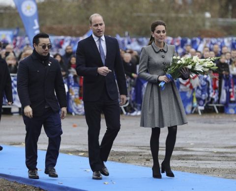 Britain's Prince William and Kate Duchess of of Cambridge walk with Aiyawatt Srivaddhanaprabha, left, the son of Leicester City owner Vichai Srivaddhanaprabha, as they view tributes to those who died in a helicopter crash near to Leicester City Football Club's King Power Stadium, in Leicester, England, Wednesday Nov. 28, 2018.   The helicopter crashed in flames in a car park next to the soccer club's stadium shortly after it took off from the pitch following a Premier League game with club owner Vichai Srivaddhanaprabha aboard. (Aaron Chown/PA via AP)