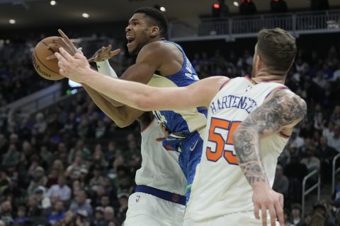 Milwaukee Bucks' Giannis Antetokounmpo is fouled as he drives between New York Knicks' Isaiah Hartenstein and Julius Randle during the second half of an NBA basketball game Friday, Nov. 3, 2023, in Milwaukee. The Bucks won 110-105. (AP Photo/Morry Gash)