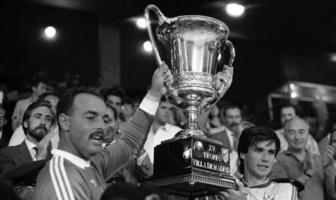 The Liverpool goalkeeper Bruce Grobbelaar, left, and captain Alan Hansen of the team hold the trophy of the Villa de Madrid after their victory 1-0 over the Atletico de Madrid on Sunday, August 23, 1987. Madrid's mayor Juan Barranco, left, stands by. (AP Photo/Toka)