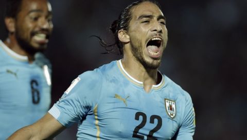 Uruguay's Martin Caceres, right, celebrates after scoring against Chile during a 2018 FIFA World Cup qualifying soccer match in Montevideo, Tuesday, Nov. 17, 2015. (AP Photo/Victor R. Caivano)