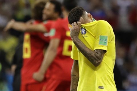 Brazil's Neymar reacts as Belgium players celebrate after Brazil is knocked out by Belgium following their quarterfinal match at the 2018 soccer World Cup in the Kazan Arena, in Kazan, Russia, Friday, July 6, 2018. (AP Photo/Andre Penner)