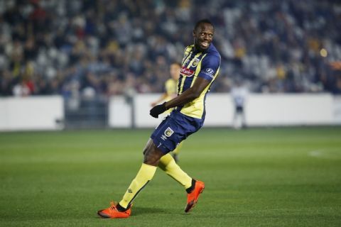 Usain Bolt overruns across the pitch during a friendly trial match between the Central Coast Mariners and the Central Coast Select in Gosford, Australia, Friday, Aug. 31, 2018. Bolt, who holds the world records for the 100- and 200-meter sprints and is an eight-time Olympic gold medalist, is hoping to earn a contract with the Mariners for the 2018-19 season in Australia's top-flight competition. (AP Photo/Steve Christo)