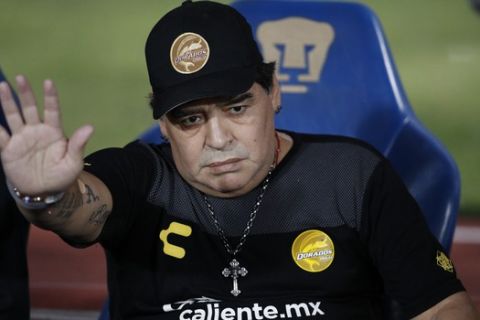 Dorados' Head Coach Diego Maradona waves as he takes his seat on the bench ahead of the start of Dorados' Copa MX quarterfinal match against Pumas at Olympic University Stadium in Mexico City, Tuesday, March 12, 2019. Pumas defeated the Dorados 3-0.(AP Photo/Rebecca Blackwell)