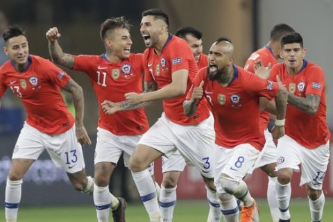 Chile's players, from left to right, Esteban Pavez, Arturo Vidal, Guillermo Maripan, Eduardo Vargas and Erick Pulgar celebrate beating Colombia 5-4 in a penalty kick shoot-out in a Copa America quarterfinal soccer match at the Arena Corinthians in Sao Paulo, Brazil, Friday, June 28, 2019. Chile qualified to the semifinals of the South American soccer tournament. (AP Photo/Andre Penner)