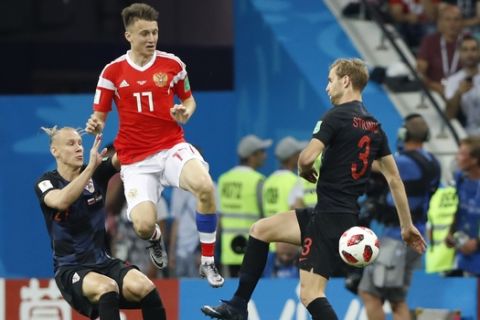 Russia's Alexander Golovin, centre, vies for the ball with Croatia's Domagoj Vida, left, and Ivan Strinicduring the quarterfinal match between Russia and Croatia at the 2018 soccer World Cup in the Fisht Stadium, in Sochi, Russia, Saturday, July 7, 2018. (AP Photo/Darko Bandic)