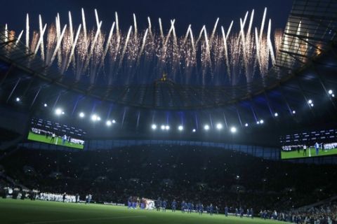 Fireworks explode above the stadium as the teams stand on the pitch before the start of the English Premier League soccer match between Tottenham Hotspur and Crystal Palace, the first Premiership match at the new Tottenham Hotspur stadium in London, Wednesday, April 3, 2019. (AP Photo/Kirsty Wigglesworth)