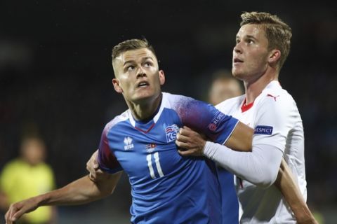 Iceland's Alfred Finnbogason, left, is challenged by Switzerland's Nico Elvedi during the UEFA Nations League soccer match between Iceland and Switzerland at Laugardalsvollur stadium in Reykjavik, Iceland, Monday Oct. 15, 2018. (AP Photo/Brynjar Gunnarsson)