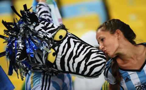 RIO DE JANEIRO, BRAZIL - JUNE 15:  An Argentina fans kisses as a fan in fancy dress prior to the 2014 FIFA World Cup Brazil Group F match between Argentina and Bosnia-Herzegovina at Maracana on June 15, 2014 in Rio de Janeiro, Brazil.  (Photo by Matthias Hangst/Getty Images)