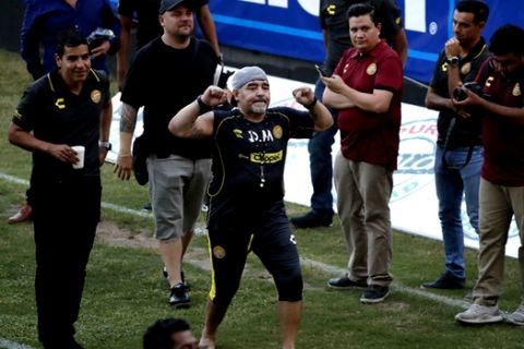 Former soccer great Diego Maradona says goodbye to the fans in stands, after a training session at the Dorados de Sinaloa soccer club stadium, after Maradona was presented as the new manager of the Dorados in Culiacan, Mexico, Monday, Sept. 10, 2018. Maradona, whose public battles with cocaine made him soccer's poster child for the perils of substance abuse, is setting up camp in Mexico's drug cartel heartland as the new coach of a second-tier team. (AP Photo/Marco Ugarte)