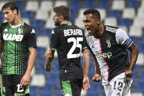 Juventus' Alex Sandro, right, celebrates after scoring a goal during a Serie A soccer match between Sassuolo and Juventus at the Mapei Stadium in Reggio Emilia, Italy, Wednesday, July 15, 2020. (Massimo Paolone/LaPresse via AP)