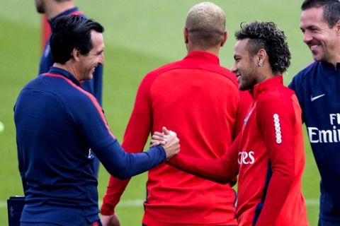 Paris Saint-Germain's coach Unai Emery, left, greets Neymar during a training session at the Camp des Loges training center in Saint Germain en Laye, west of Paris, Friday, Aug. 11, 2017. (AP Photo/Kamil Zihnioglu)