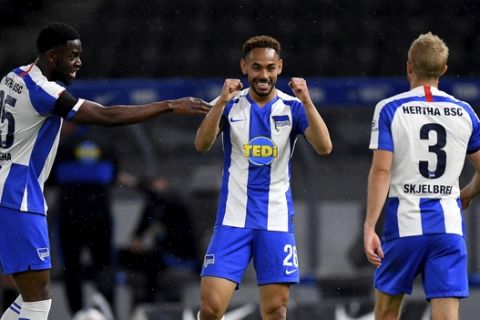 Hertha's Matheus Santos Carneiro Da Cunha, center, celebrates scoring his side's third goal during the German Bundesliga soccer match between Hertha BSC Berlin and 1. FC Union Berlin in Berlin, Germany, Friday, May 22, 2020. The German Bundesliga is the world's first major soccer league to resume after a two-month suspension because of the coronavirus pandemic. (Stuart Franklin/Pool Photo via AP)