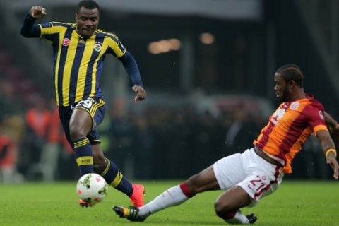 Galatasaray's Aurelien Chedjou, right, and Emmanuel Emenike of Fenerbahce fight for the ball during their Turkish League soccer derby match at the TT Arena stadium in Istanbul, Turkey, Saturday, Oct. 18, 2014.(AP Photo)