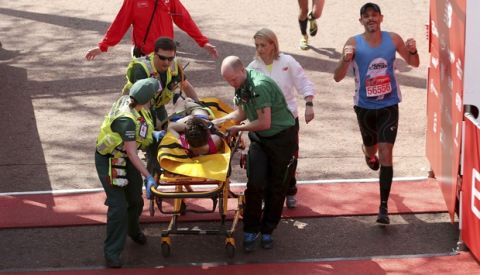 A runner is stretchered across the line by medical staff during the 2018 Virgin Money London Marathon, Sunday April 22, 2018.  Medical condition of this competitor is unknown, but hot weather has proved to be a considerable problem for some runners. (Paul Harding/PA via AP)
