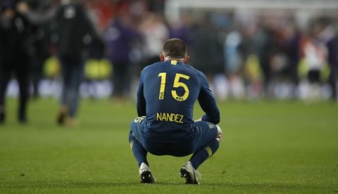 Nahitan Nandez of Argentina's Boca Juniors sits alone the pitch after Boca lost the Copa Libertadores final soccer match to Argentina's River Plate at the Santiago Bernabeu stadium in Madrid, Spain, Monday, Dec. 10, 2018. (AP Photo/Thanassis Stavrakis)