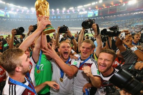 RIO DE JANEIRO, BRAZIL - JULY 13: Benedikt Hoewedes of Germany raises the World Cup trophy with teammates after defeating Argentina 1-0 in extra time during the 2014 FIFA World Cup Brazil Final match between Germany and Argentina at Maracana on July 13, 2014 in Rio de Janeiro, Brazil.  (Photo by Martin Rose/Getty Images)