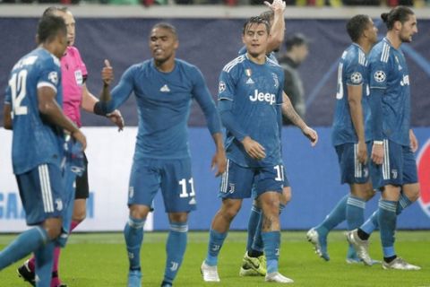 Juventus' Douglas Costa, 2nd left, celebrates with teammates after scoring his side's second goal during the Champions League Group D soccer match between Lokomotiv Moscow and Juventus at the Lokomotiv Stadium in Moscow, Russia, Wednesday, Nov. 6, 2019. (AP Photo/Pavel Golovkin)