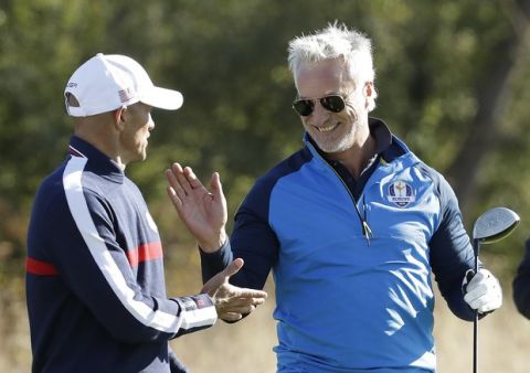 Former French soccer player David Ginola, right, greets surf legend Kelly Slater of the US after he played from the 14th tee in the Ryder Cup Celebrity Challenge match at Le Golf National in Saint-Quentin-en-Yvelines, outside Paris, France, Tuesday, Sept. 25, 2018. The 42nd Ryder Cup will be held in France from Sept. 28-30, 2018 at Le Golf National. (AP Photo/Matt Dunham)