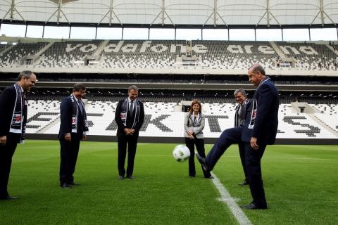 In this Sunday, April 10, 2016 photo Turkeys President Recep Tayyip Erdogan, right, kicks a soccer ball during the opening ceremony of Besiktas new stadium, Vodafone Arena, in Istanbul. No fans were allowed however, for the opening of the stadium of Besiktas, one of Turkeys three leading soccer clubs. Media reports said the move was aimed to avoid possible protest against Erdogan. From left to right are Sports Minister Cagatay Kilic, Prime Minister Ahmet Davutoglu, Besiktas Chairman Fikret Orman, Vodafone Regional CEO Serpil Timuray and former president Abdullah Gul. (Basin Bulbul, Presidential Press Service Pool via AP)