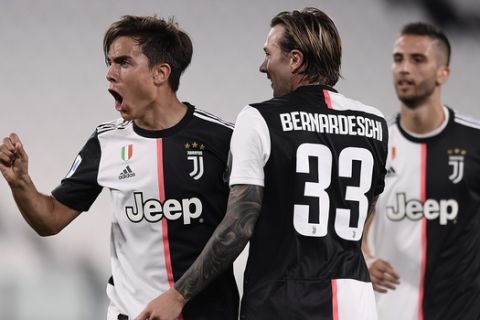 Juventus' Paulo Dybala, left, celebrates after a goal during the Serie A soccer match between Juventus and Lecce, at the Allianz Stadium in Turin, Italy, Friday, June 26, 2020. (Fabio Ferrari/LaPresse via AP)