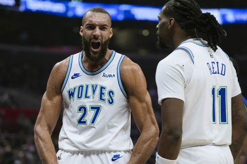 Minnesota Timberwolves center Rudy Gobert, center, reacts with center Naz Reid after drawing an and-one call during the second half of an NBA basketball game against the Los Angeles Clippers, Monday, Feb. 12, 2024, in Los Angeles. (AP Photo/Ryan Sun)