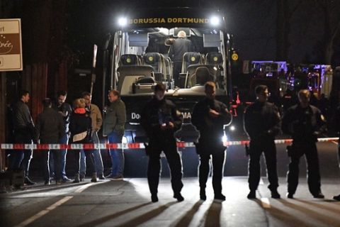 Police officers stand in front of Dortmund's damaged team bus after an explosion before the Champions League quarterfinal soccer match between Borussia Dortmund and AS Monaco in Dortmund, western Germany, Tuesday, April 11, 2017.  (AP Photo/Martin Meissner)