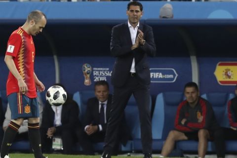 Spain's Andres Iniesta, controls the ball near Spain head coach Fernando Hierro, center, during the group B match between Spain and Morocco at the 2018 soccer World Cup at the Kaliningrad Stadium in Kaliningrad, Russia, Monday, June 25, 2018. (AP Photo/Czarek Sokolowski)
