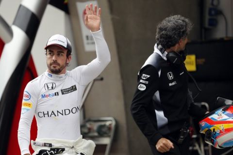 McLaren driver Fernando Alonso of Spain, left, waves during the qualifying session for the Chinese Formula One Grand Prix at Shanghai International Circuit in Shanghai, China, Saturday, April 16, 2016. (AP Photo, POOL)