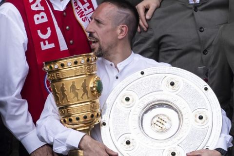 Soccer player Franck Ribery from FC Bayern Munich celebrates withy the trophies for the German league Bundesliga championship and the German soccer cup on the balcony of the city hall in Munich, Sunday, May 26, 2019. (Sven Hoppe/dpa via AP)