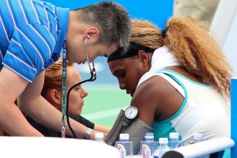 Medical personnel treat Serena Williams of the US (R) during her match against France's Alize Cornet at Wuhan Open tennis tournament in Wuhan, in China's Hubei province on September 23, 2014. Top seed Serena Williams had to be helped from the court as she retired ill during her first set at the inaugural Wuhan Open in China. CHINA OUT   AFP PHOTOSTR/AFP/Getty Images ORIG FILE ID: 533698585