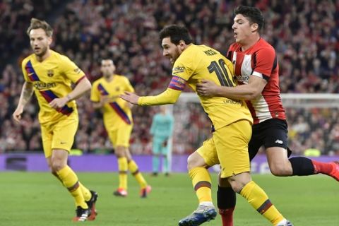 Barcelona's Lionel Messi, left, fights for the ball with Athletic Bilbao's Ander Capa during the Spanish Copa del Rey, quarter final, soccer match between Athletic Bilbao and Barcelona at San Mames stadium in Bilbao, Spain, Thursday, Feb. 6, 2020. (AP Photo/Alvaro Barrientos)
