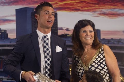 Real Madrids striker Cristiano Ronaldo, left, poses with his mother Dolores and his son Cristiano Ronaldo Junior after receiving a silver boot award for scoring the most goals for the club during a ceremony at the Santiago Bernabeu stadium in Madrid, Spain, Friday Oct. 2, 2015. Real Madrid paid tribute to Ronaldo, who recently overtook Raul Gonzalez to become the club's all-time highest goalscorer. (AP Photo/Paul White)