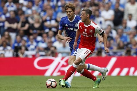 Arsenal's Mesut Ozil, right, controls the ball in front of Chelsea's Marcos Alonso during the English FA Cup final soccer match between Arsenal and Chelsea at Wembley stadium in London, Saturday, May 27, 2017. (AP Photo/Kirsty Wigglesworth)