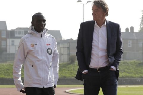 Marathon world record holder Kenya's Eliud Kipchoge and Britain's richest person Jim Ratcliffe walk for photographers at the Iffley Road Track, in Oxford, England, Tuesday, April 30, 2019, where British athlete Roger Bannister, in 1954 ran to become the first person ever to break the four minute mile barrier. Eliud Kipchoge has funding from Britain's richest man, Jim Ratcliffe, who founded chemicals group INEOS, for his bid to break the two-hour marathon barrier again later this year. (AP Photo/Matt Dunham)