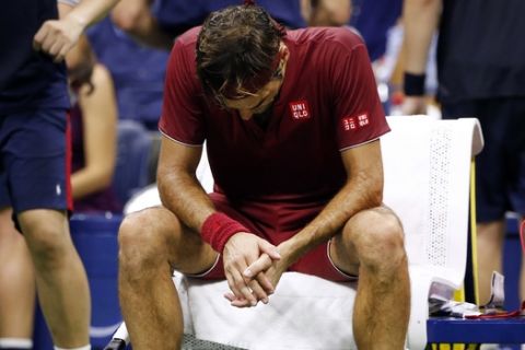 El tenista suizo Roger Federer, sentado delante de un ventilador durante un descanso en su partido contra el australiano John Millman, en los octavos de final del Abierto de Estados Unidos, el 4 de septiembre de 2018, en Nueva York. (AP Foto/Jason DeCrow)