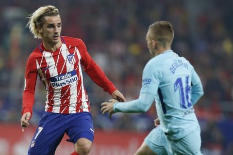 Atletico Madrid's Antoine Griezmann, left, tussles for the ball with Barcelona's Gerard Deulofeu during a Spanish La Liga soccer match between Atletico Madrid and Barcelona at the Metropolitano stadium in Madrid, Saturday, Oct. 14, 2017. The match ended in a 1-1 draw. (AP Photo/Francisco Seco)