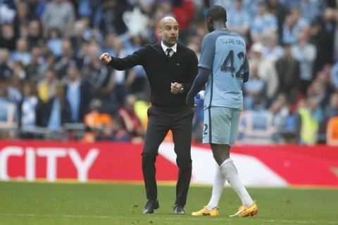 Manchester City manager Pep Guardiola, left, talks to Manchester City's Yaya Toure during the English FA Cup semifinal soccer match between Arsenal and Manchester City at Wembley stadium in London, Sunday, April 23, 2017. (AP Photo/Alastair Grant)