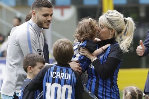 Inter Milan's Mauro Icardi is surrounded by his sons and wife Wanda Nara after receiving a prize for his100 goals with the Inter Milan jersey, prior to the start of a Serie A soccer match between Inter Milan and Hellas Verona, at the San Siro stadium in Milan, Italy, Saturday, March 31, 2018. (AP Photo/Luca Bruno)