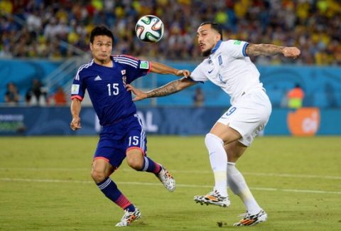 NATAL, BRAZIL - JUNE 19: Yasuyuki Konno of Japan competes for the ball with Konstantinos Mitroglou of Greece during the 2014 FIFA World Cup Brazil Group  C match between Japan and Greece at Estadio das Dunas on June 19, 2014 in Natal, Brazil.  (Photo by Jamie McDonald/Getty Images)