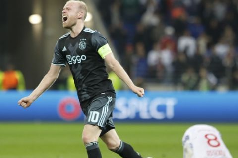 Ajax's Davy Klaassen celebrates reaching the final as Lyon's Corentin Tolisso, right,. is on the pitch after the second leg semi final soccer match between Olympique Lyon and Ajax in the Stade de Lyon, Decines, France, Thursday, May 11, 2017. Ajax lost 3-1, but continues to play the Europa League final after a 4-1 win at home. (AP Photo/Laurent Cipriani)