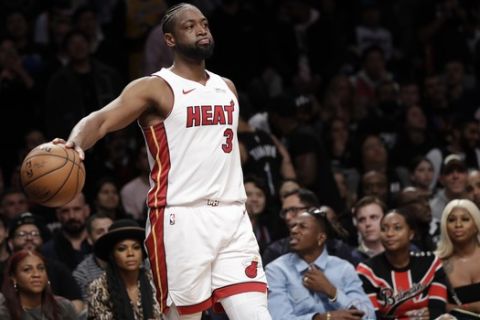 Miami Heat guard Dwyane Wade (3) holds the ball out during the second half of the team's NBA basketball game against the Brooklyn Nets, Wednesday, April 10, 2019, in New York. (AP Photo/Kathy Willens)