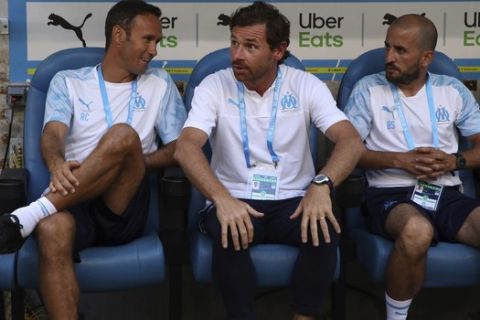 Marseille's head coach Andre Villas-Boas, center, takes his seat on the bench before the French League One soccer match between Marseille and Reims at the Velodrome Stadium in Marseille, France, Saturday, Aug. 10, 2019. (AP Photo/Daniel Cole)