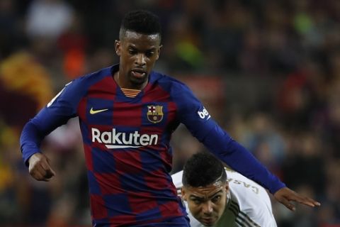 Barcelona's Nelson Semedo controls the ball during a Spanish La Liga soccer match between Barcelona and Real Madrid at Camp Nou stadium in Barcelona, Spain, Wednesday, Dec. 18, 2019. Thousands of Catalan separatists are planning to protest around and inside Barcelona's Camp Nou Stadium during Wednesday's "Clasico". (AP Photo/Joan Monfort)