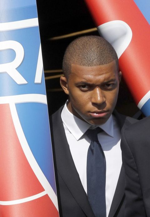French soccer player Kylian Mbappe arrives to pose with his team shirt following a press conference in Paris, Wednesday, Sept. 6, 2017. Mbappe is a young man in a big hurry and wants to "win everything" with his new club Paris Saint-Germain. (AP Photo/Christophe Ena)