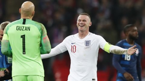 England's Wayne Rooney, right, jokes with Unites States goalkeeper Brad Guzan who stopped Rooney's shot on goal during the international friendly soccer match between England and the United States at Wembley stadium, Thursday, Nov. 15, 2018. (AP Photo/Alastair Grant)